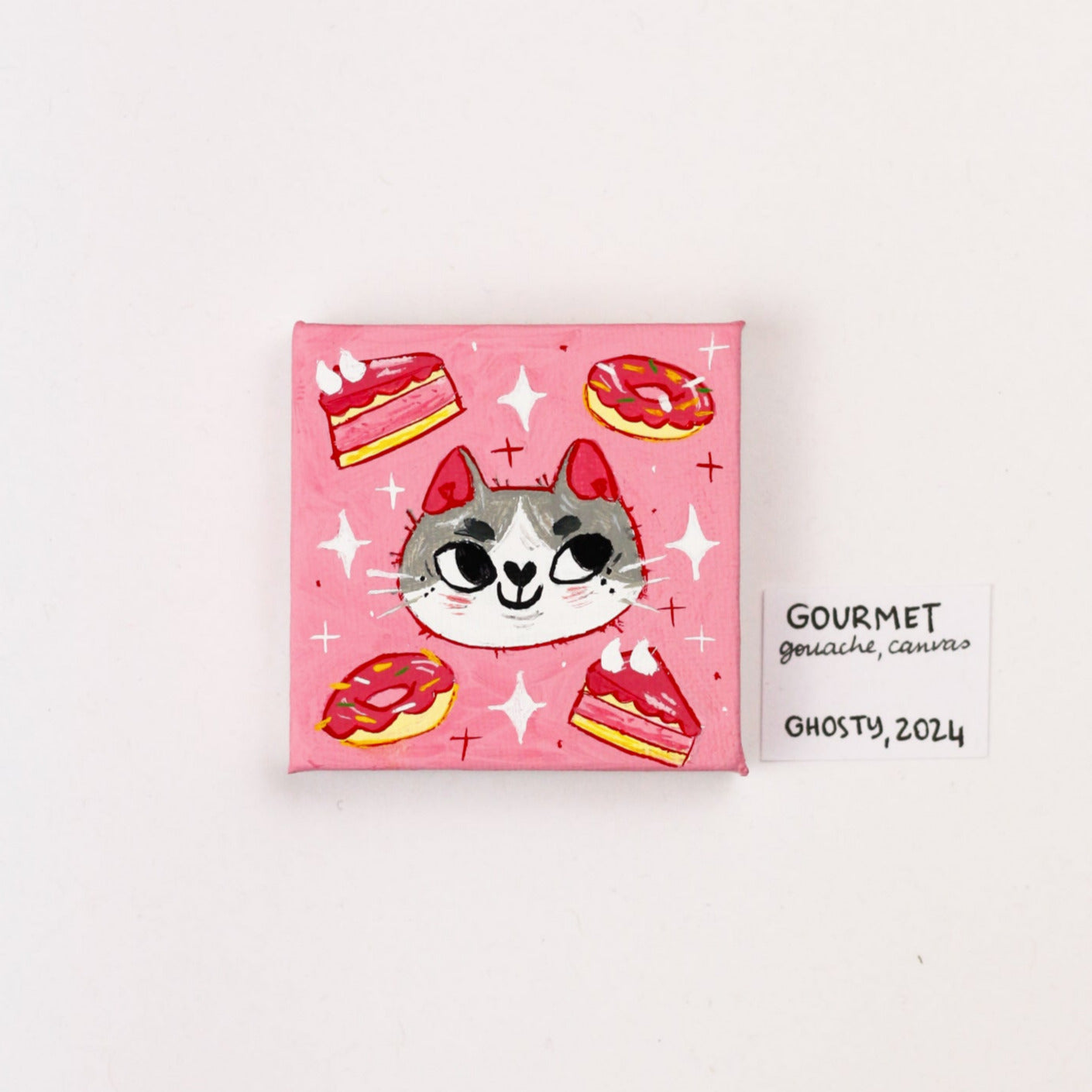 grey and white cat painting made with gouache on a pink background with cakes and donuts around